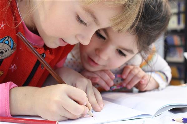 Two Preschool children drawing together